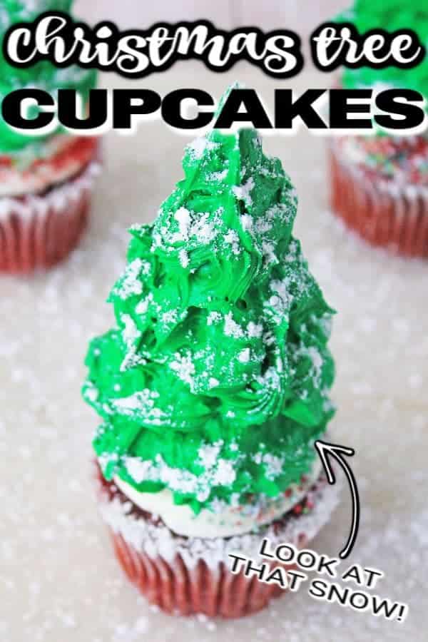 Christmas tree on top of cupcake on white table dusted in powdered sugar. 