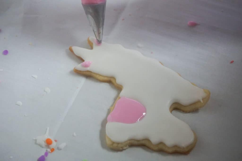 llama cookies being iced on parchment paper