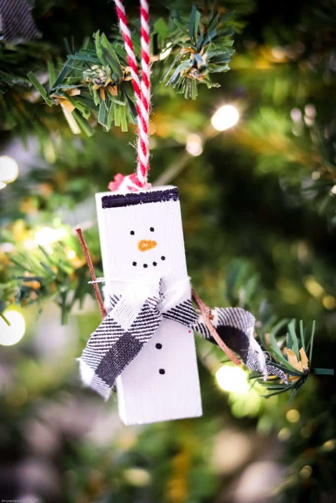 Snowman ornament made from jenga piece hanging from tree