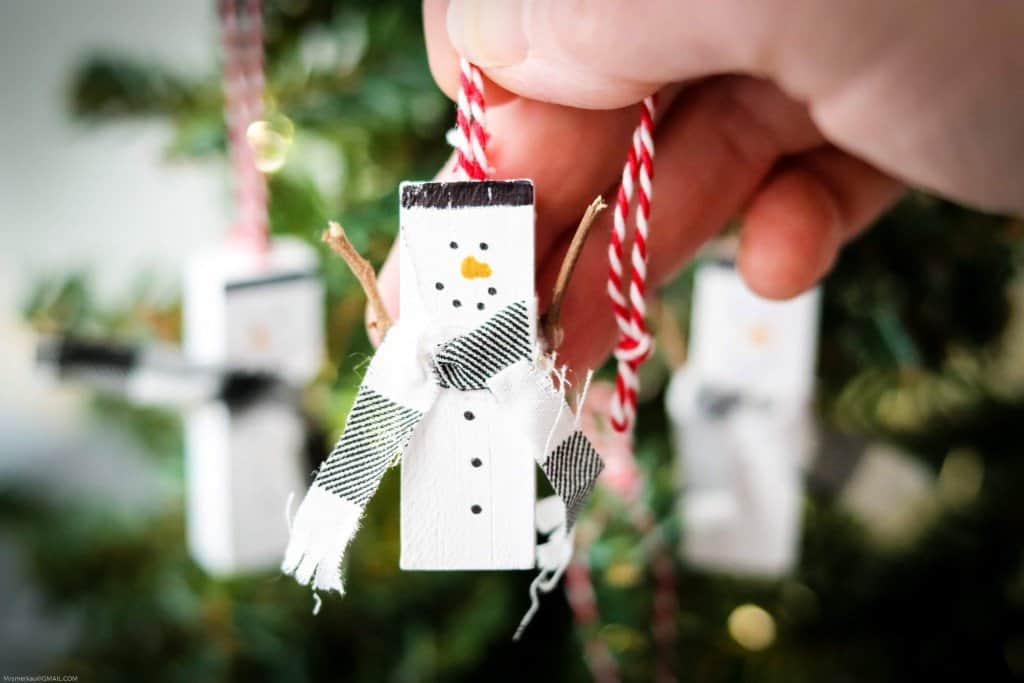 Snowman ornament made from jenga piece in woman's hand