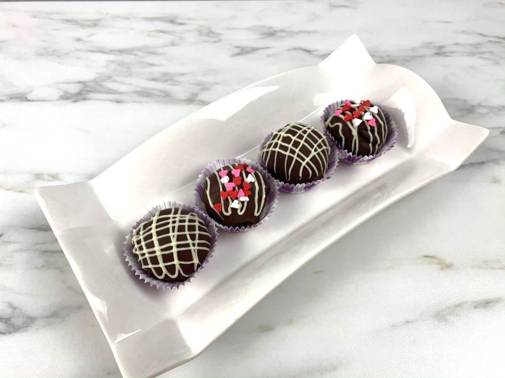 Oreo truffles with valentine sprinkles on a decorative white dish