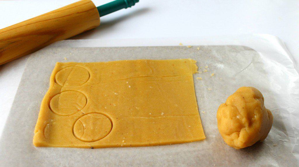 Dough being rolled and cut out in circles for keto tagalong cookies.