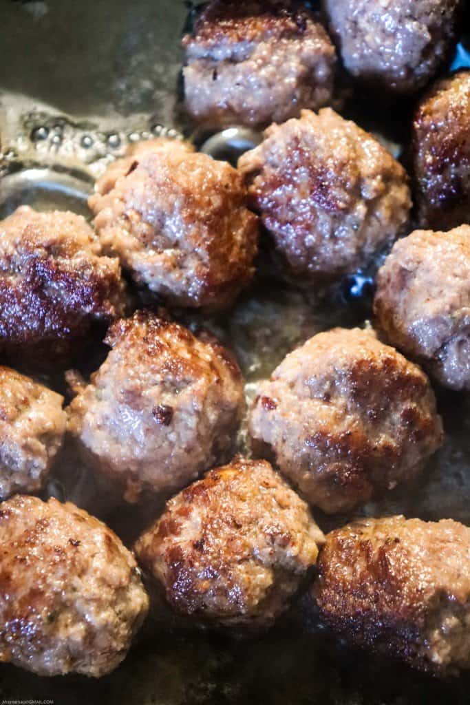 Swedish meatballs being cooked in skillet.