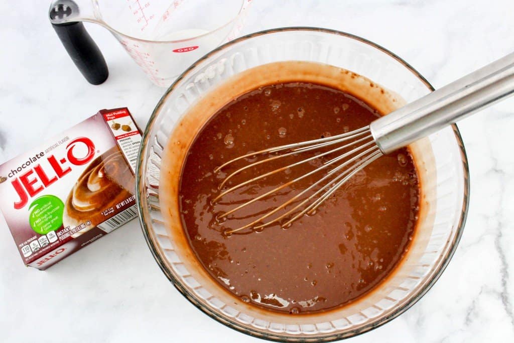 Chocolate pudding mix in mixing bowl with whisk