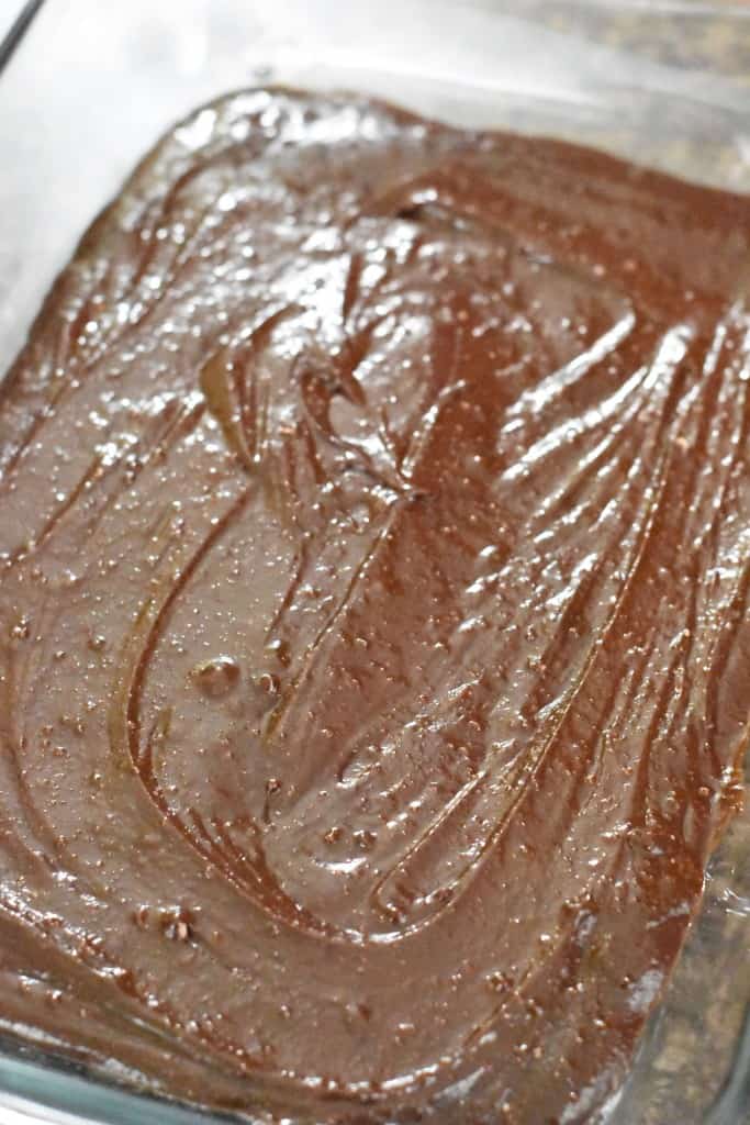 brownie batter for grasshopper bars being placed into the oven to bake