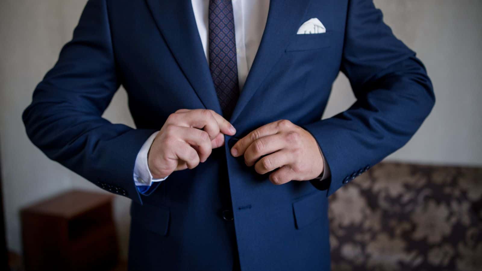 Man buttoning Suit